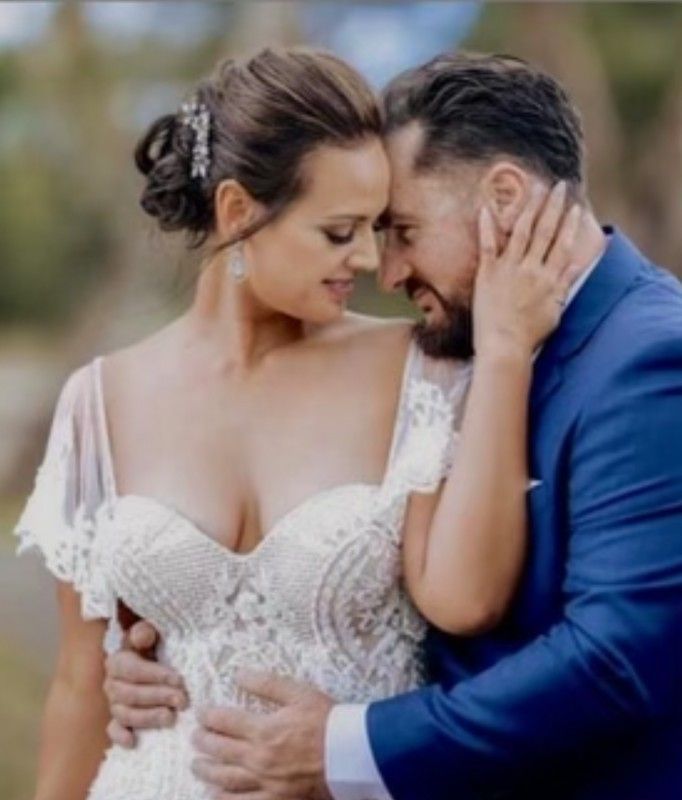 A Bride and Groom Are Hugging and Looking at Each Other