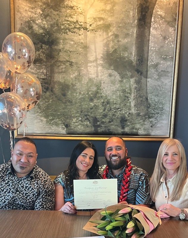 A Group of People Are Sitting at A Table Holding Balloons