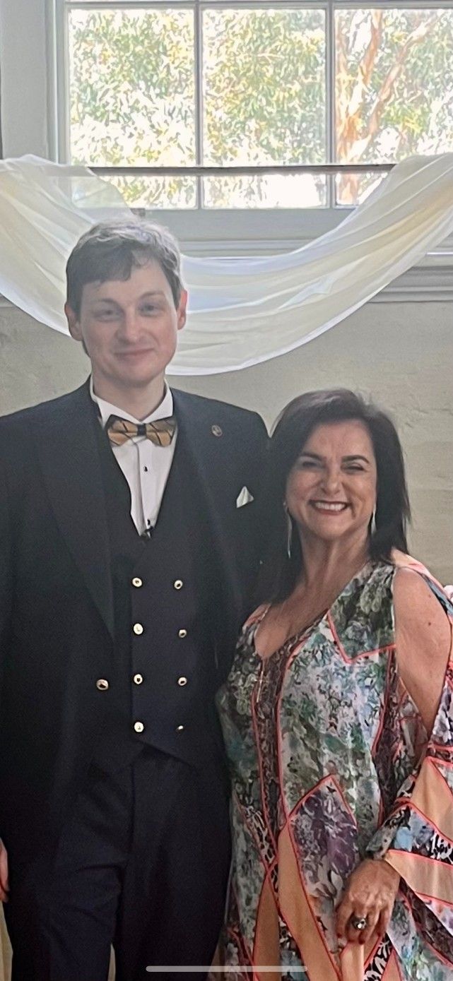 A Man In a Tuxedo and A Woman in A Dress Are Posing for A Picture