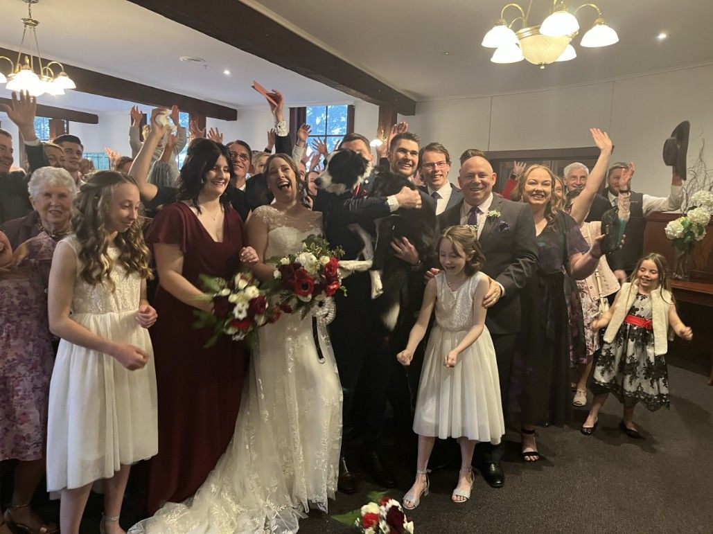 A Bride and Groom Are Posing for A Picture with Their Wedding Party