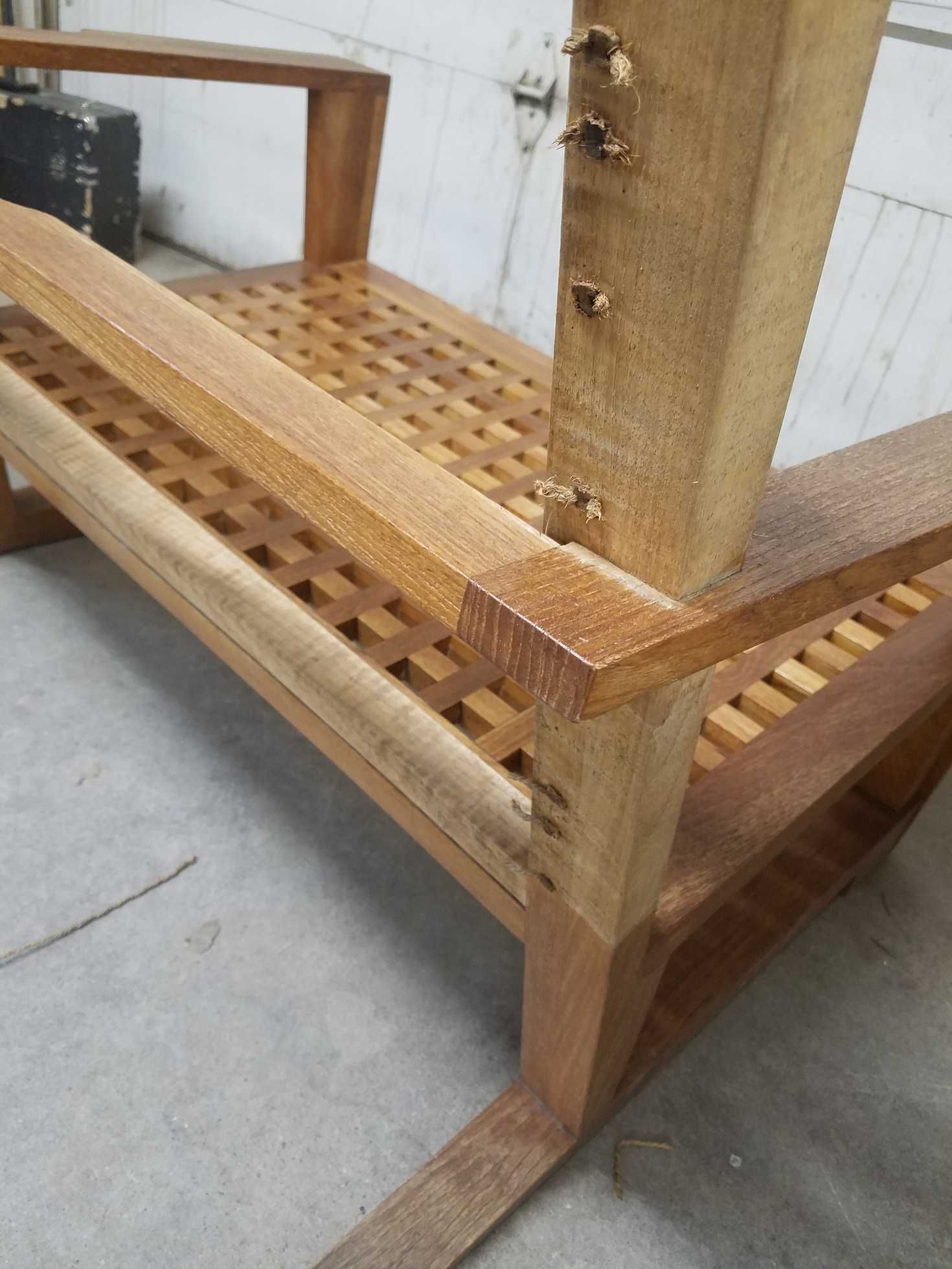 Wooden outdoor chair with a lattice seat and a light brown finish, indoors.