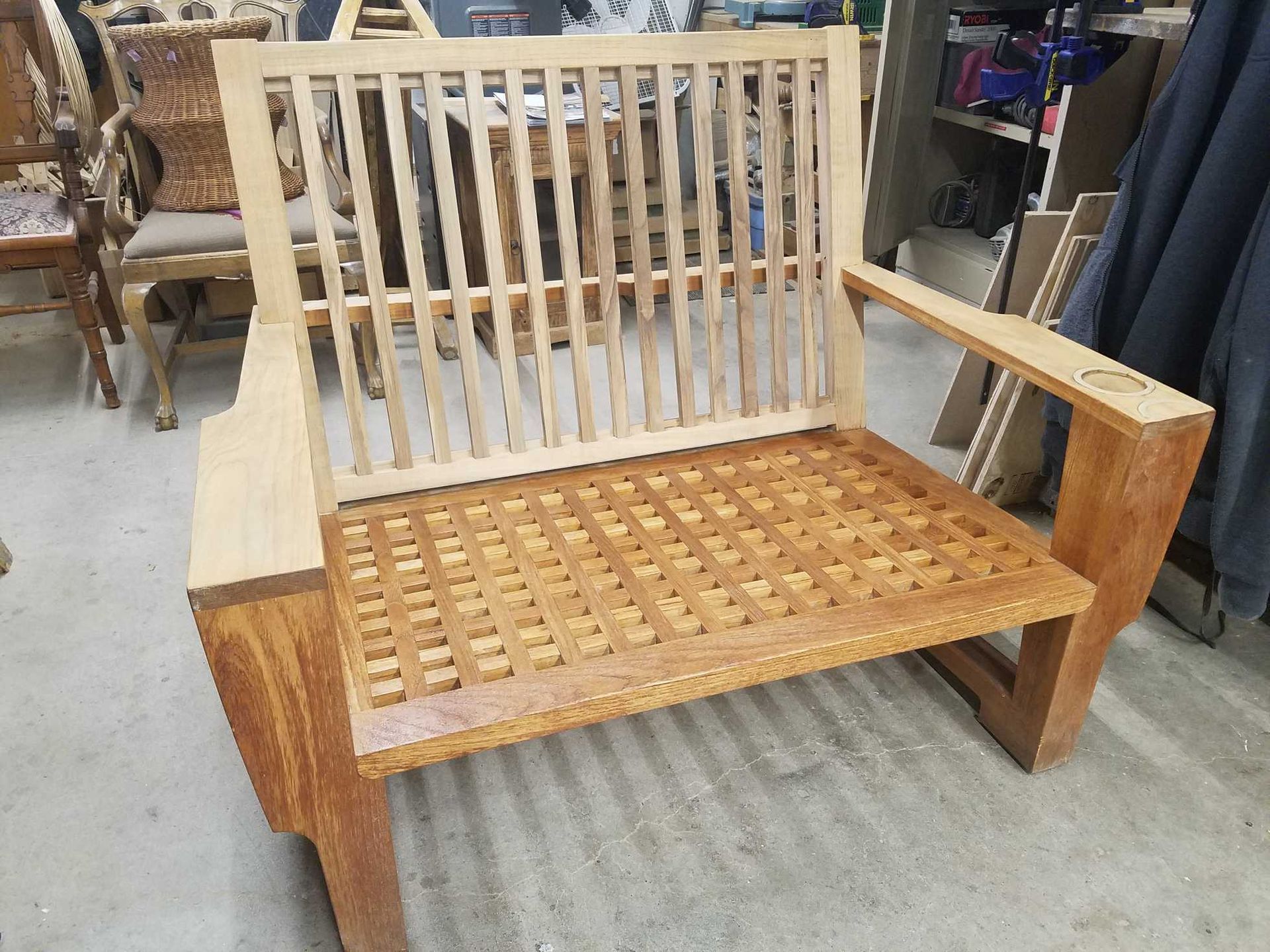 Wooden, cloud-shaped coffee table with three levels, stained brown, in a workshop setting.