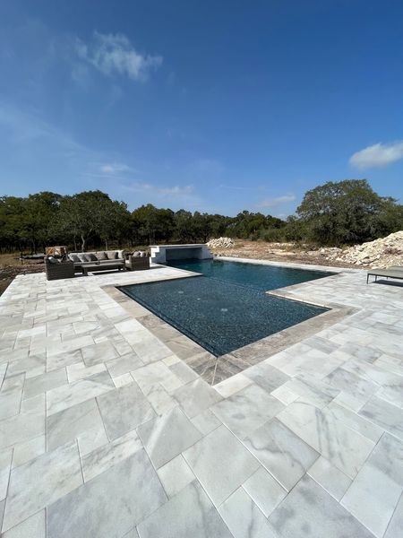 Marble decking swimming pool in New Braunfels, TX
