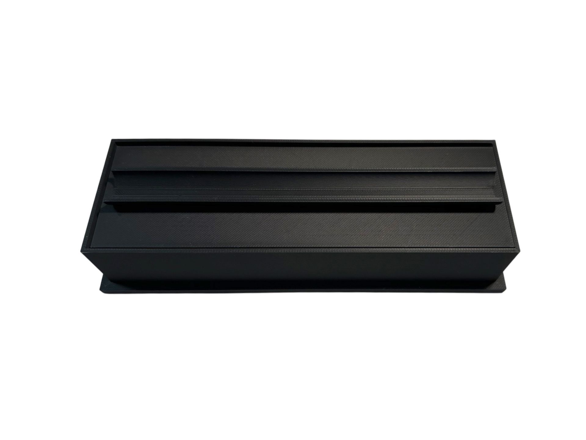 Black paper towel holder with rectangular base and angled sides.