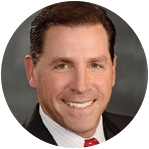 Man in suit smiling, headshot in a circular frame.