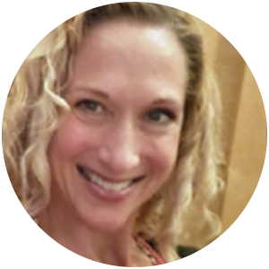 Woman with curly blonde hair, smiling, in a close-up, round frame.