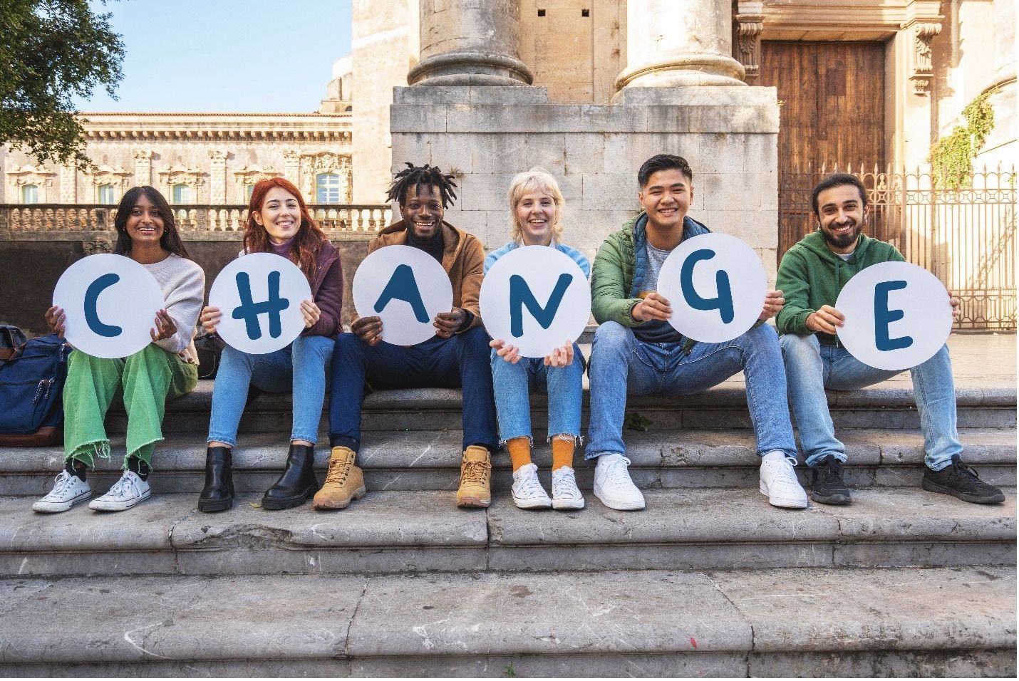 Group of people holding letters spelling