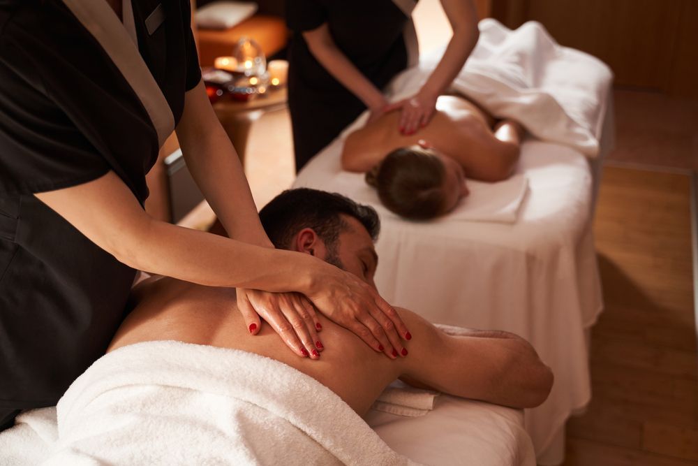 A couple is getting a massage at a spa.