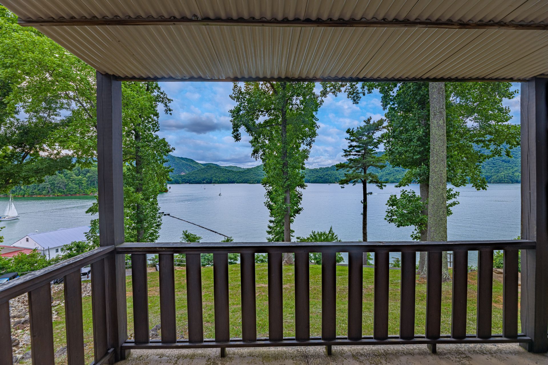 A porch with a view of a lake and trees.