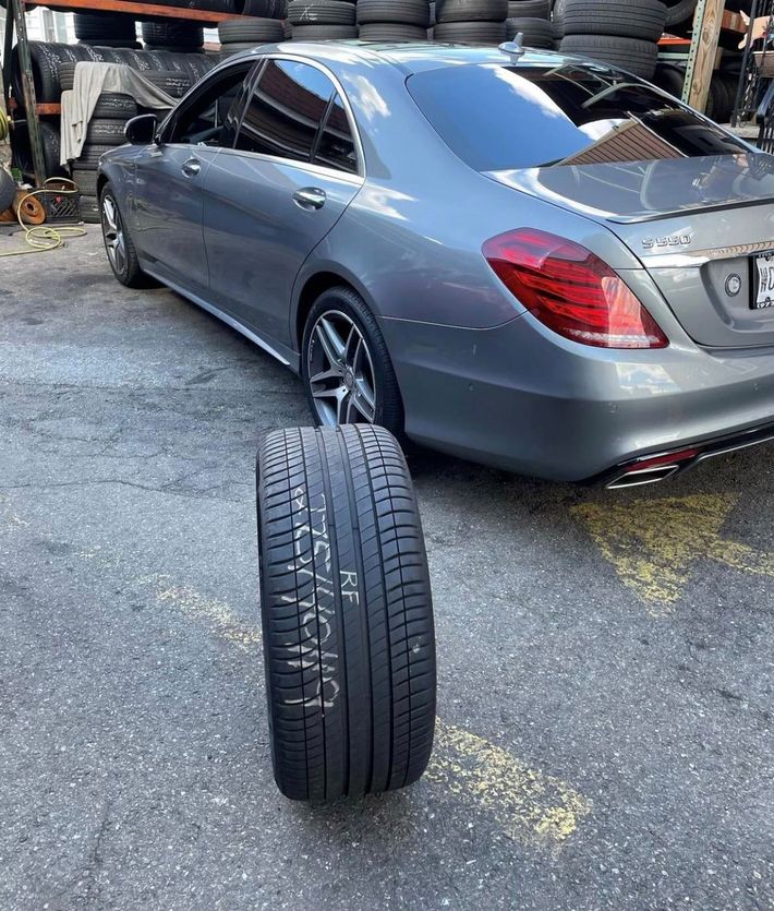 A car is parked next to a tire that says nf on it.