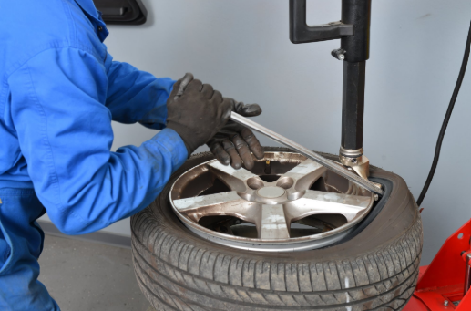 A man is changing a tire with a wrench.