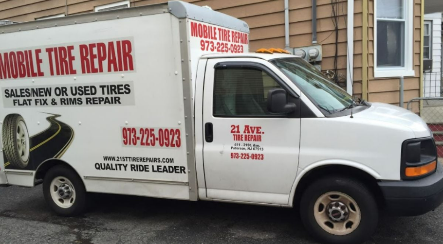 A mobile tire repair van is parked in front of a building