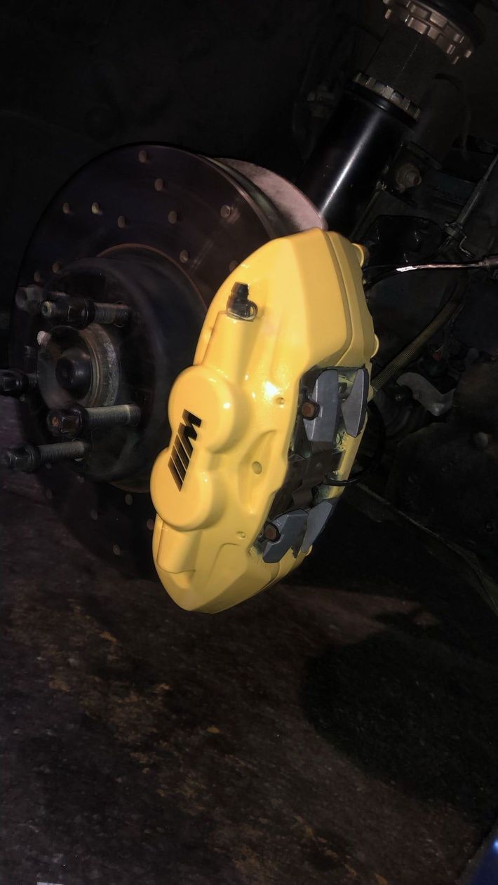 A close up of a yellow brake caliper on a car
