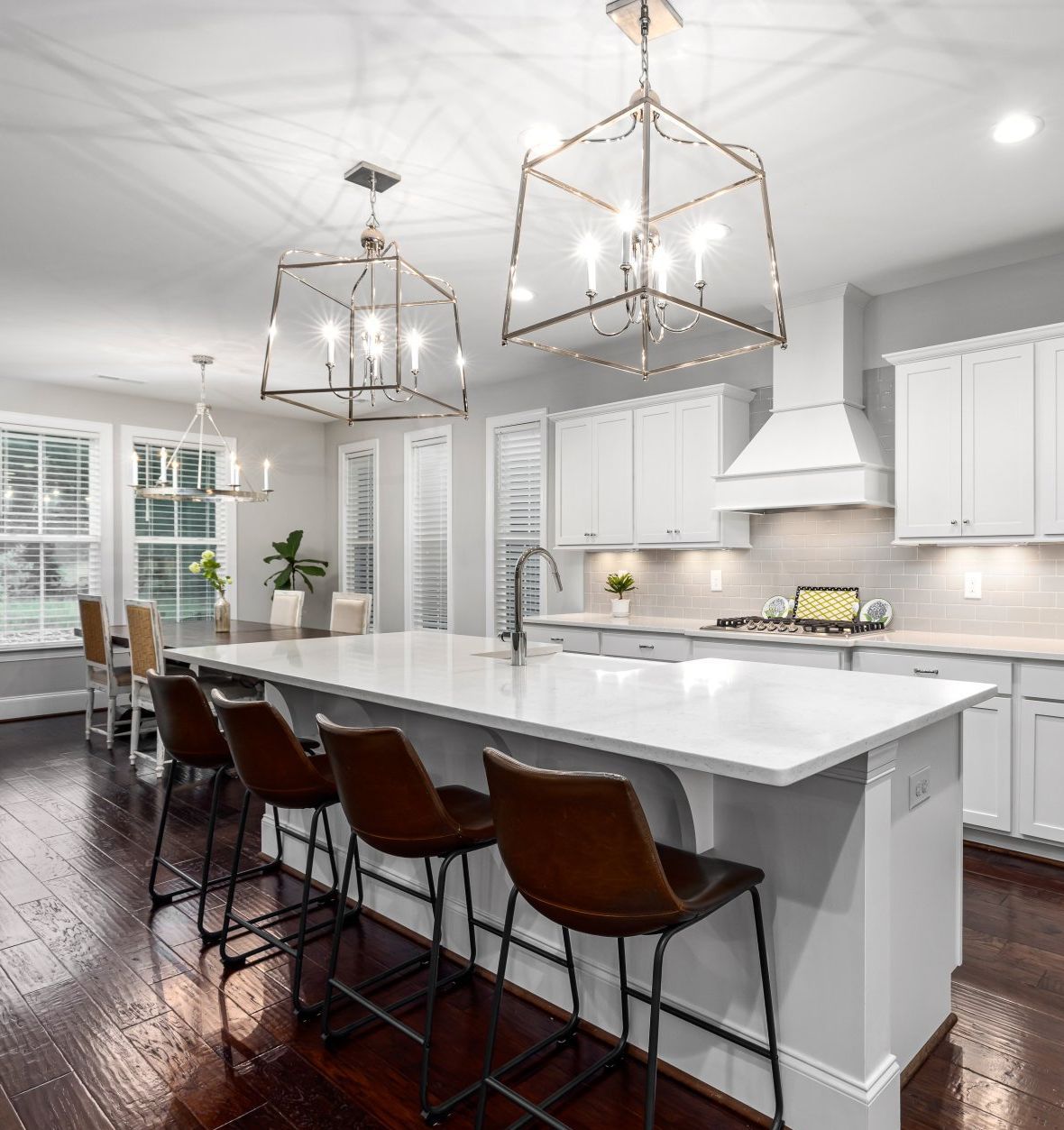 a kitchen with white cabinets, a large island, and stools: Top Kitchen Trends to Embrace in 2024