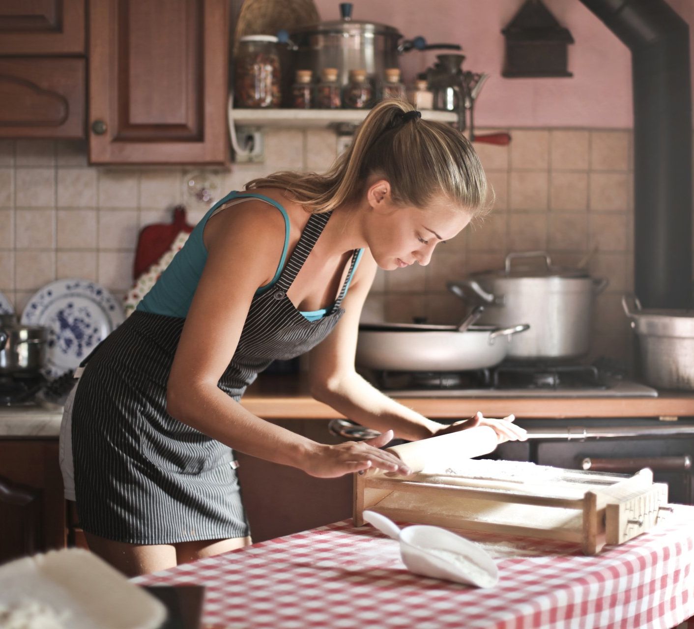 a woman in an apron is working in a kitchen
