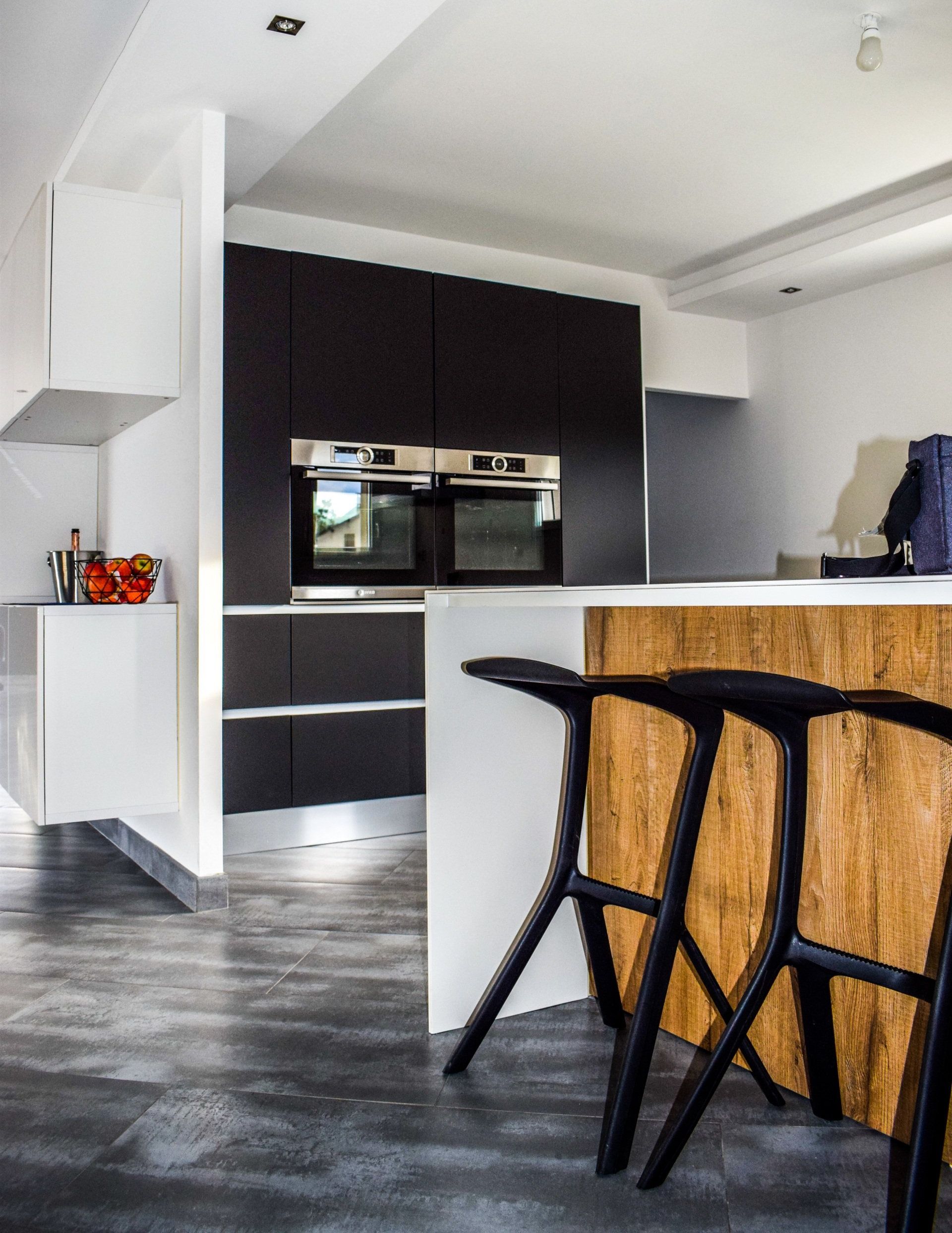 a kitchen with black stools and a wooden island: Top Kitchen Trends to Embrace in 2024