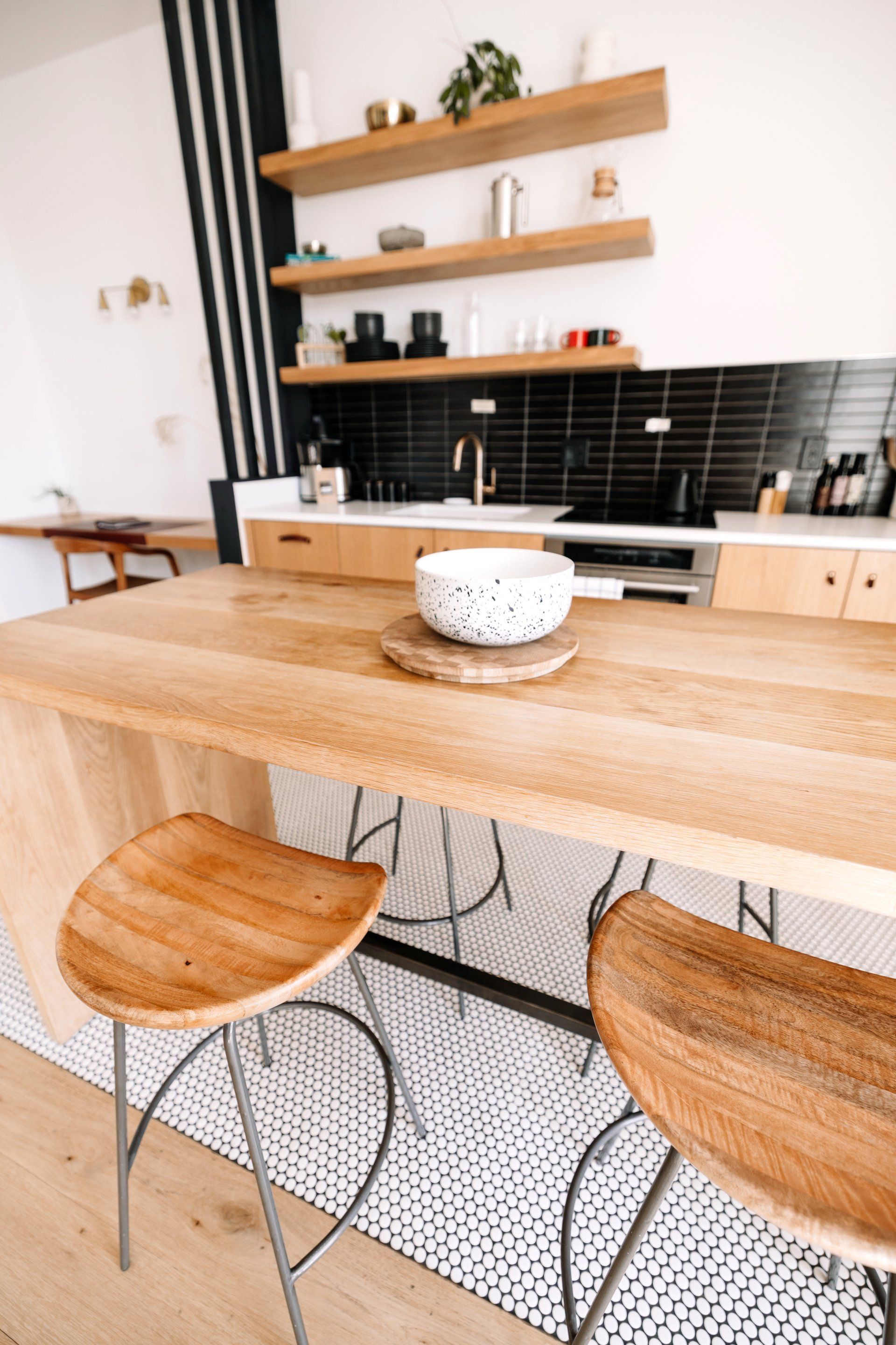 a kitchen with a wooden table and stools and a bowl on the table:  Turn Your Crowded Kitchen Into A Minimalist Space