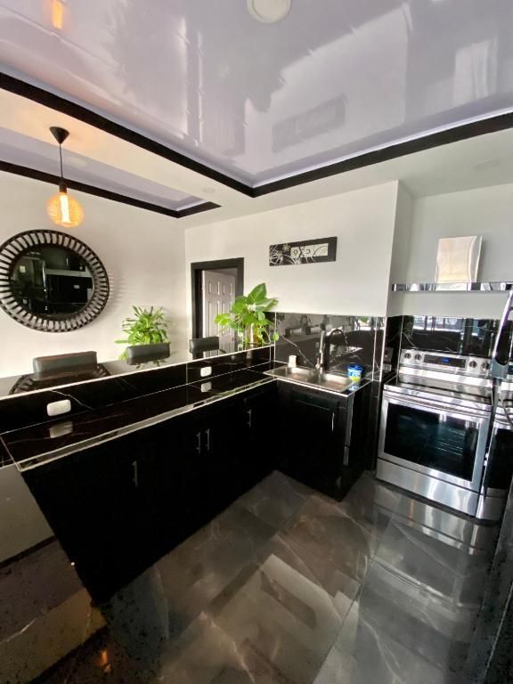 Una cocina con gabinetes negros y electrodomésticos de acero inoxidable.