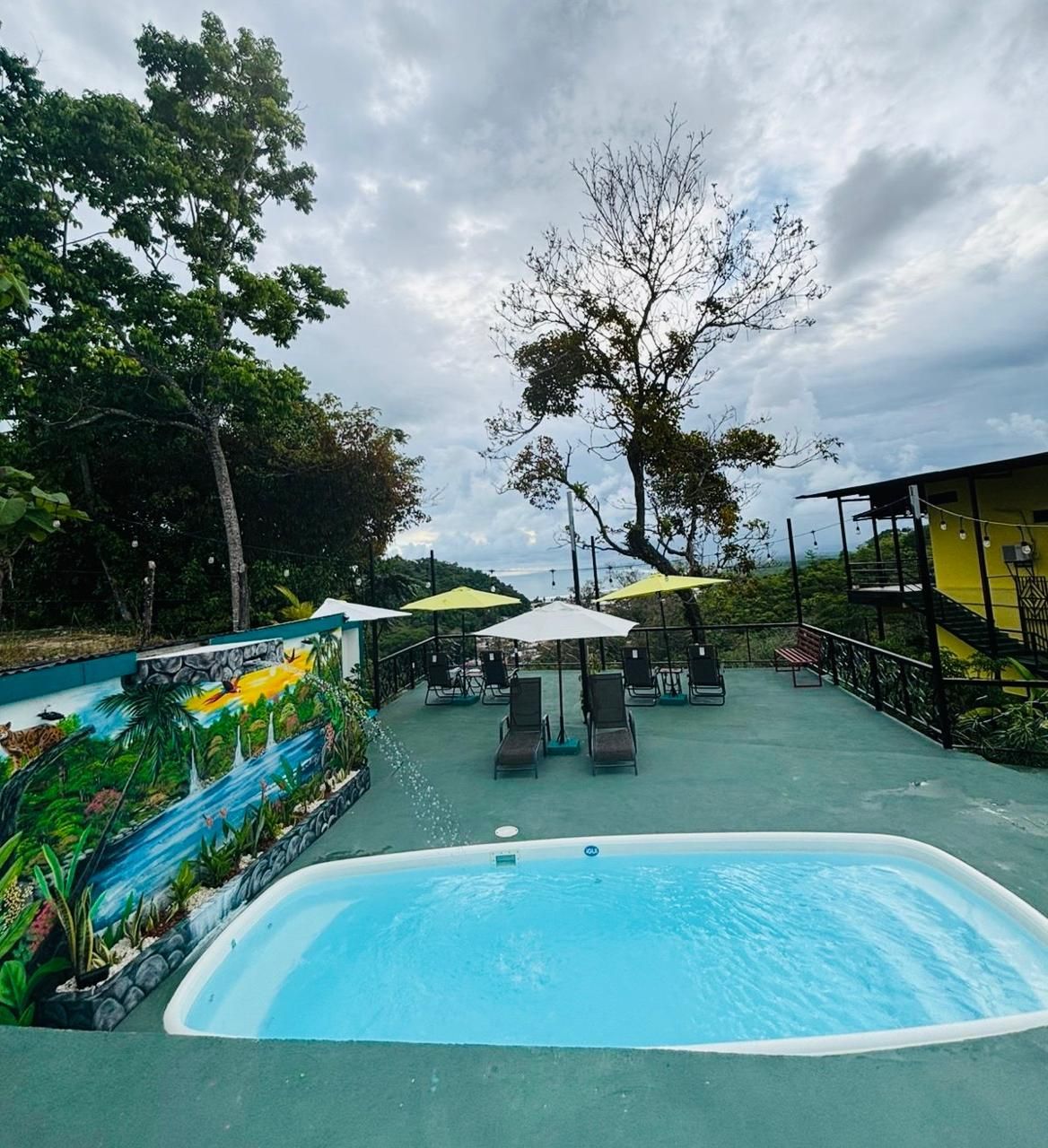 Una gran piscina rodeada de sillas y sombrillas.