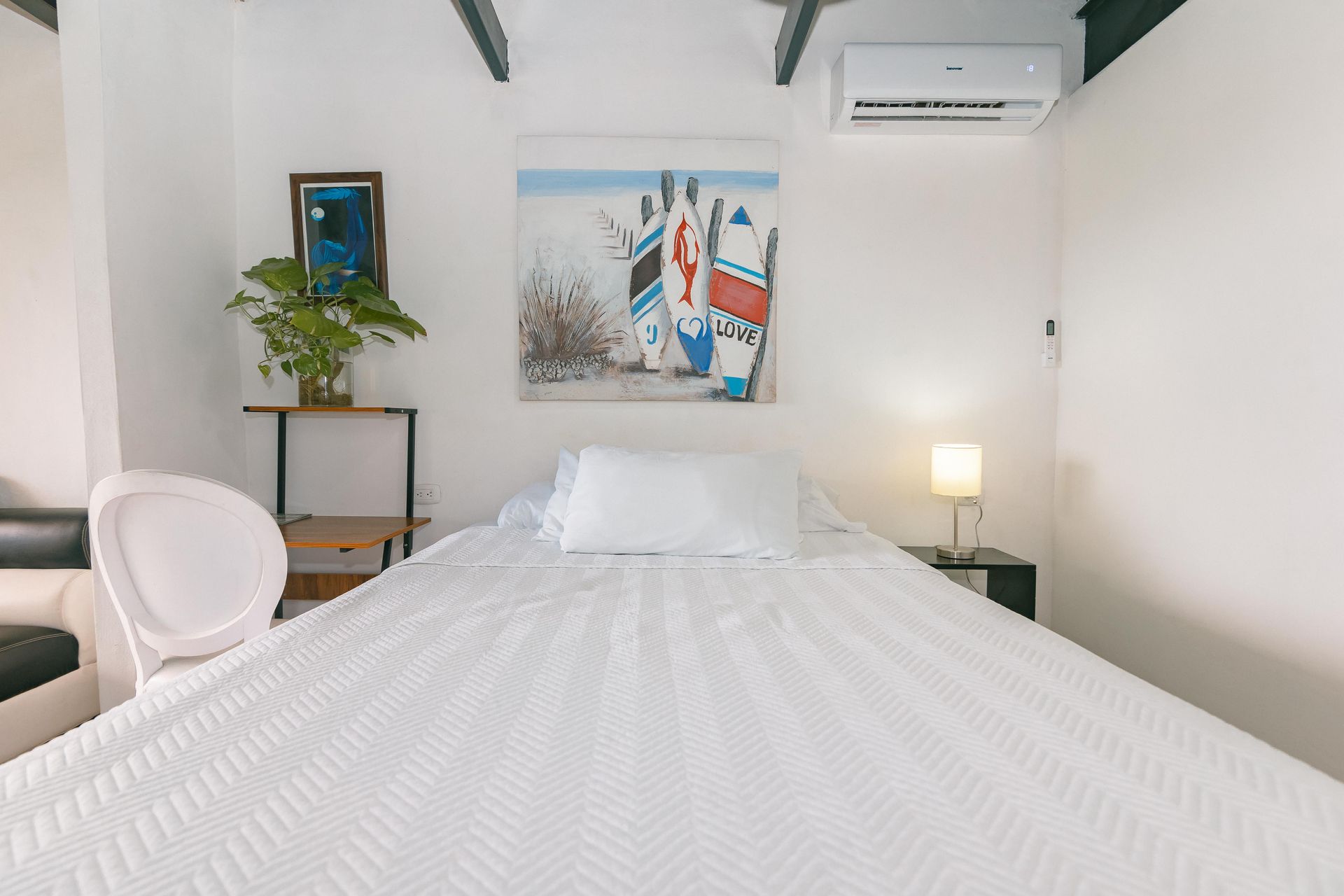 Hay un cuadro en la pared encima de la cama en la habitación.