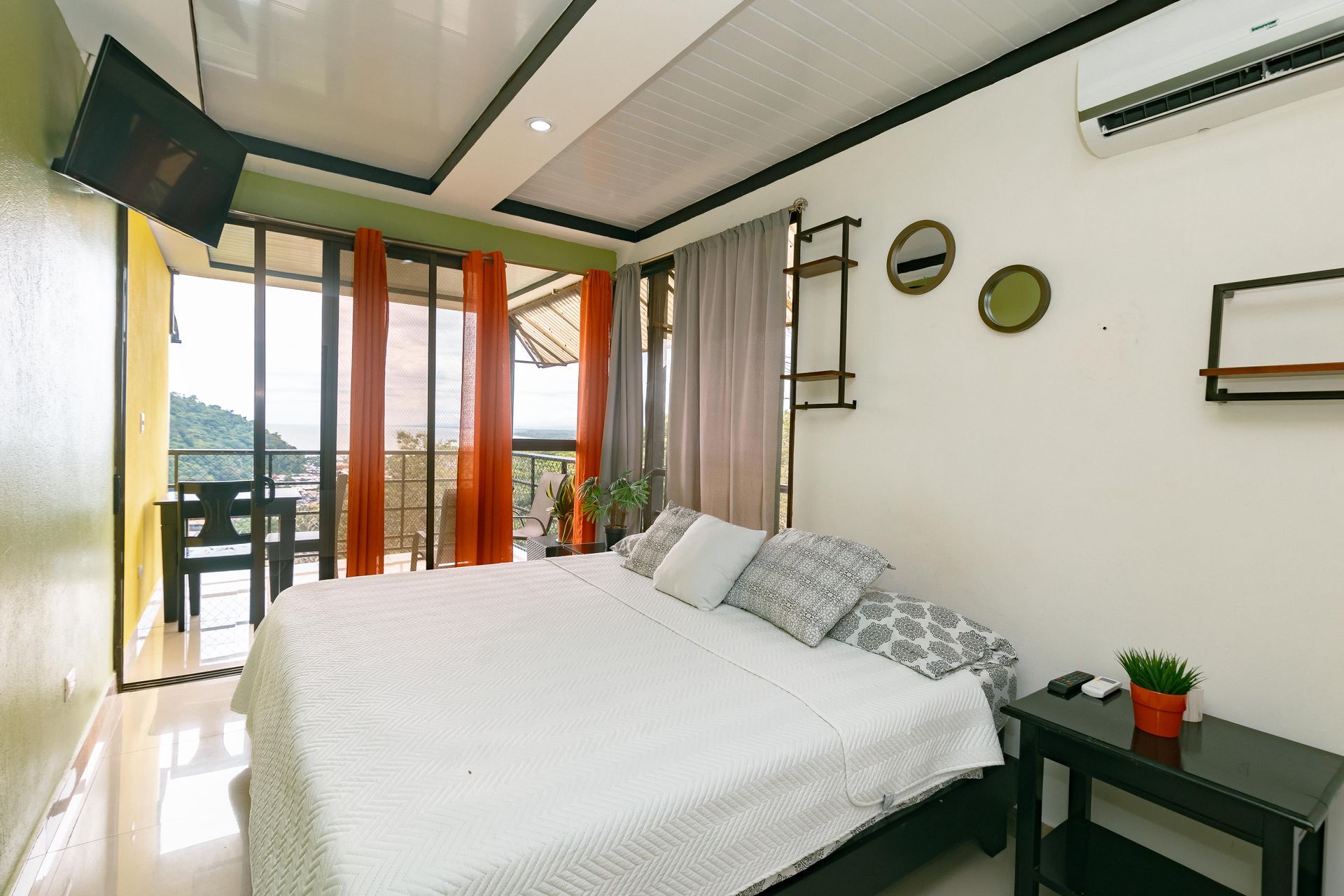 Un dormitorio con una cama king size y un televisor de pantalla plana.