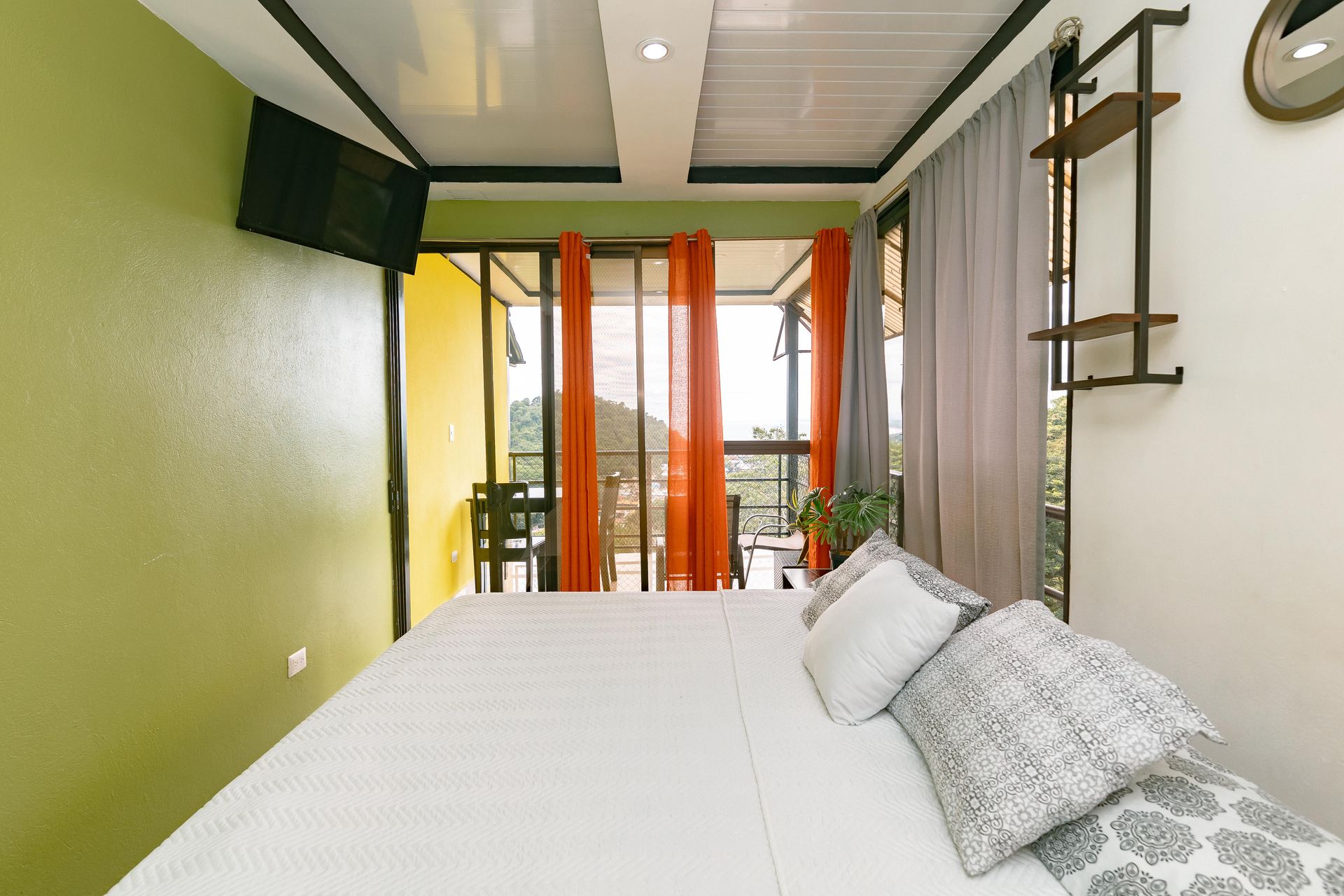 Una habitación de hotel con una cama grande y un balcón.