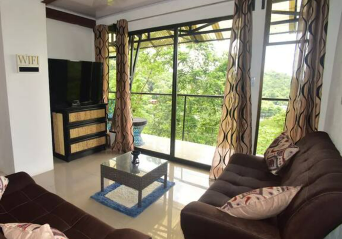 Una sala de estar con un sofá, una mesa y un televisor.