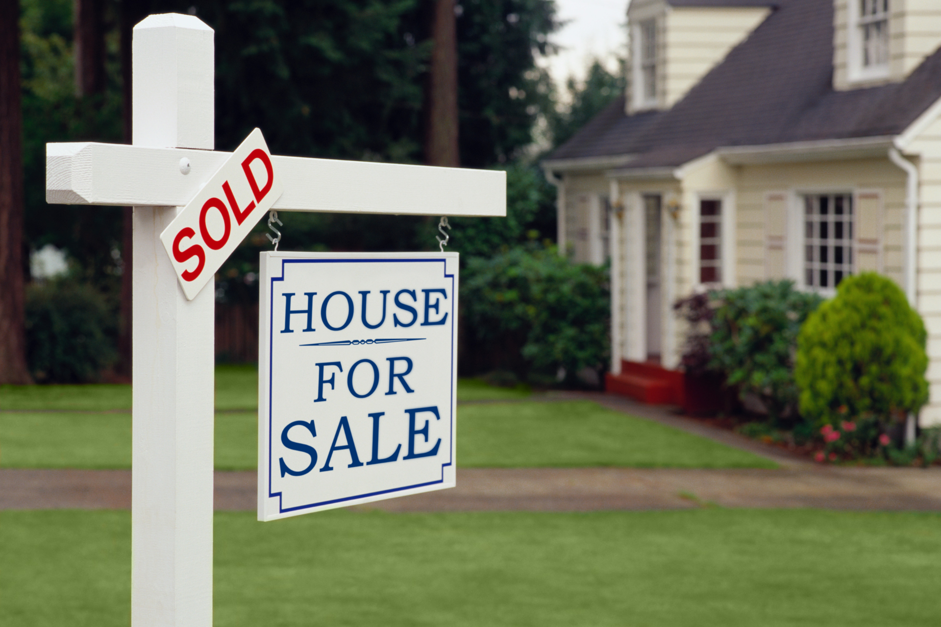 Sold house sign in front of a suburban home