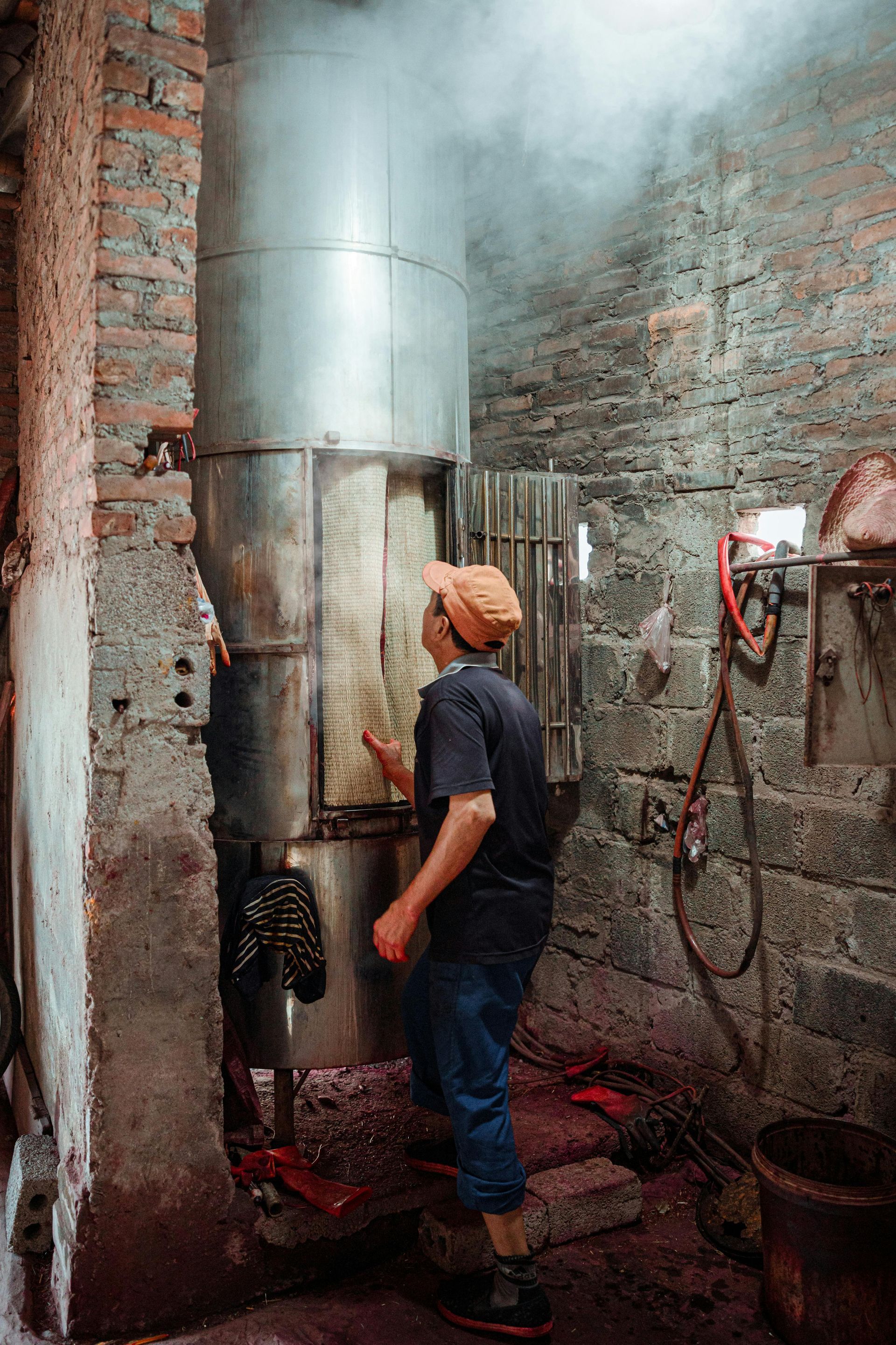 A man is standing in a room with smoke coming out of a pipe.