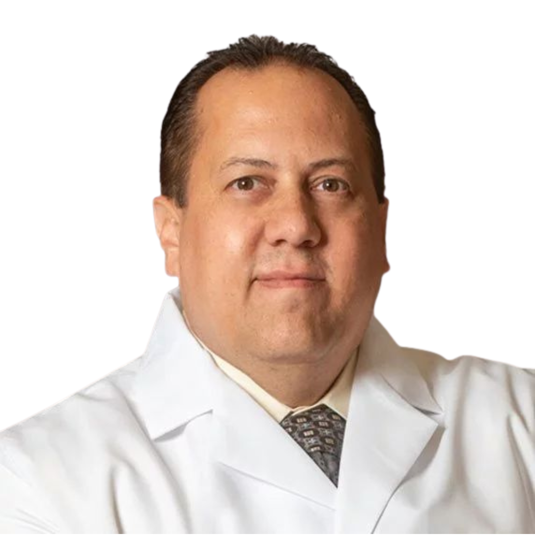 A man in a white coat and tie looks at the camera