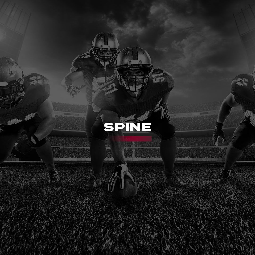 A group of football players are running with a ball on a field with the word spine in front.