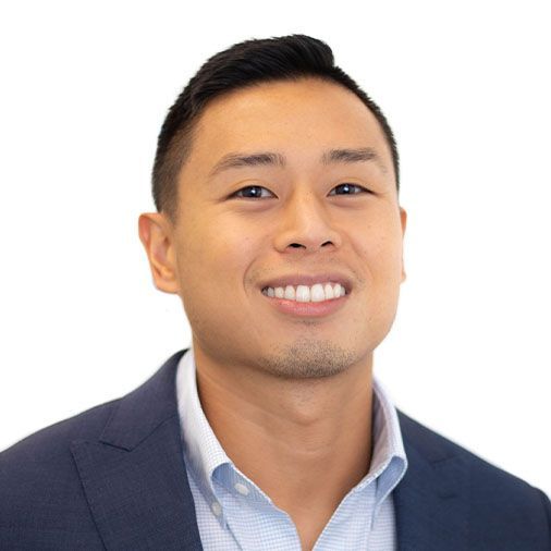 A man in a suit and blue shirt is smiling for the camera.