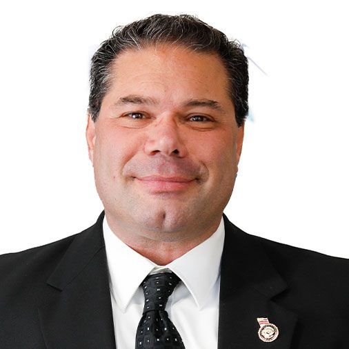 A man in a suit and tie is smiling for the camera