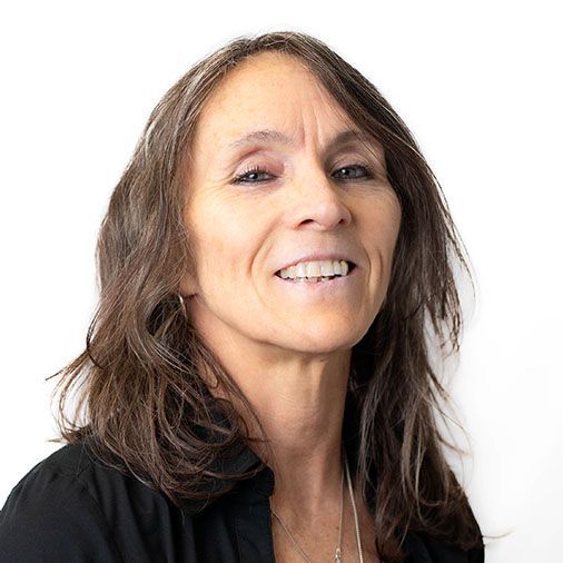 A woman with long brown hair is smiling and wearing a black shirt.