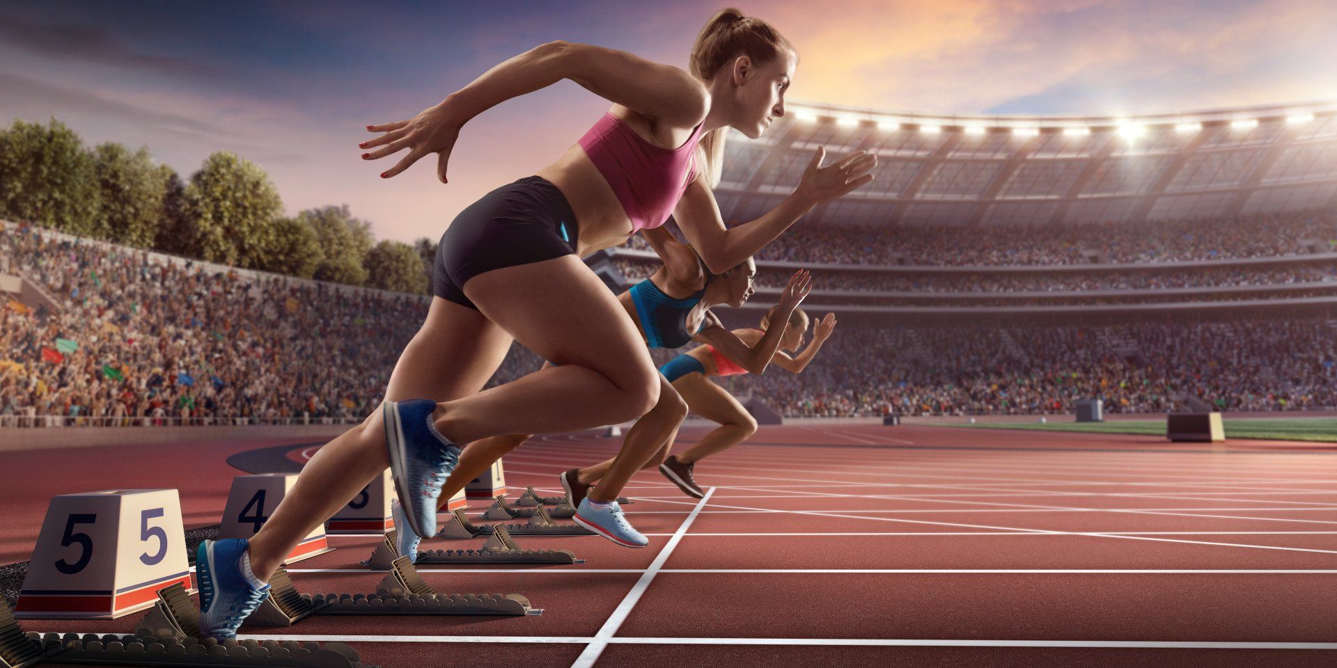 A group of women are running on a track in a stadium.