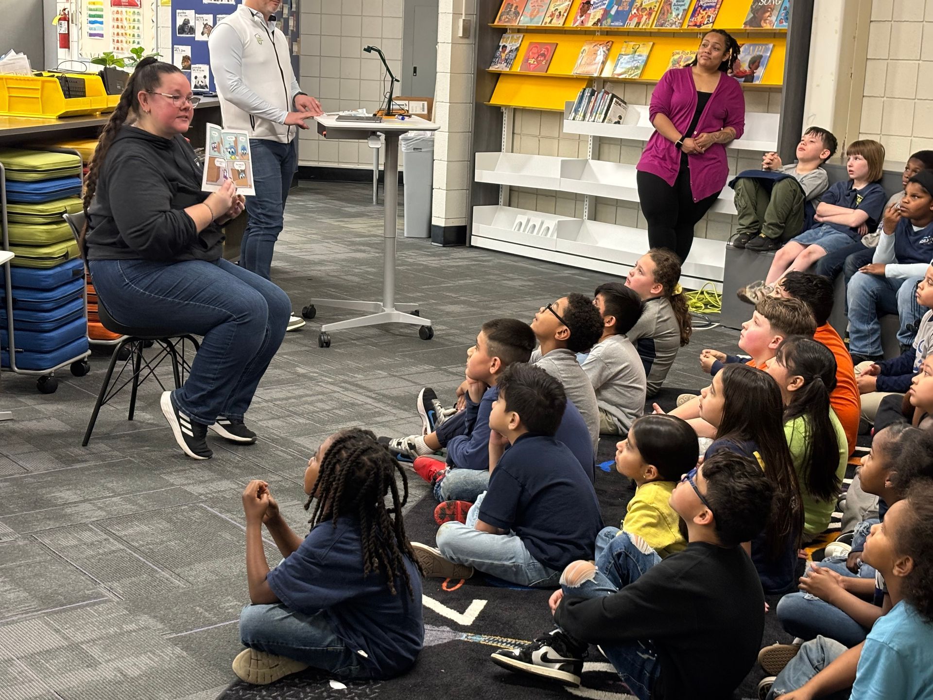 KPMG partners leading first and second grade students in a read aloud and reading activity