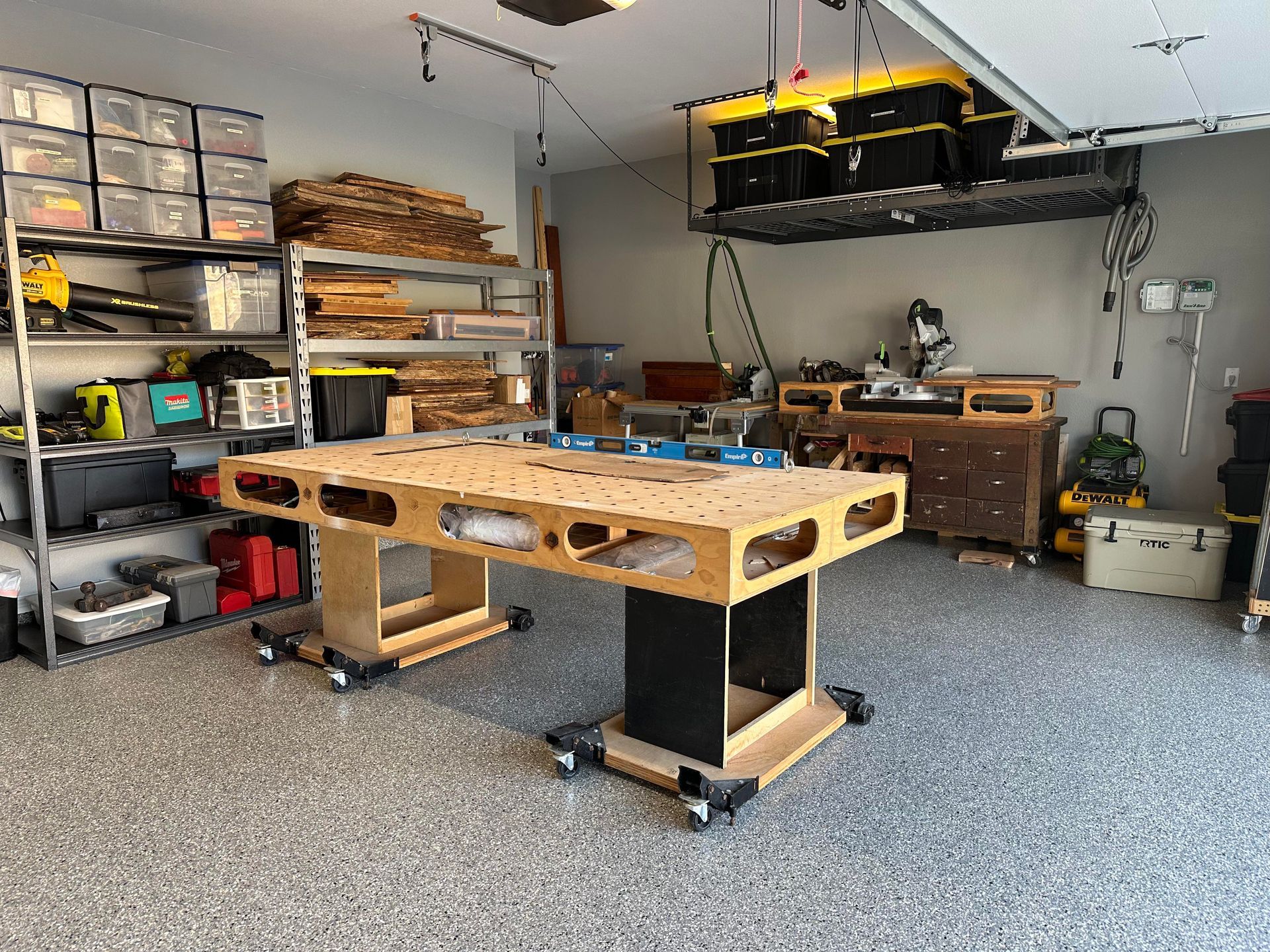 a commercial garage filled with lots of tools and a wooden workbench on new epoxy floors.