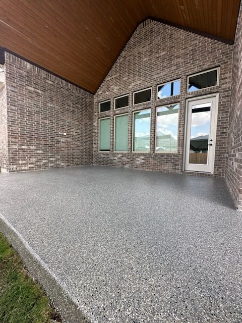 a brick house with a covered patio and a door .