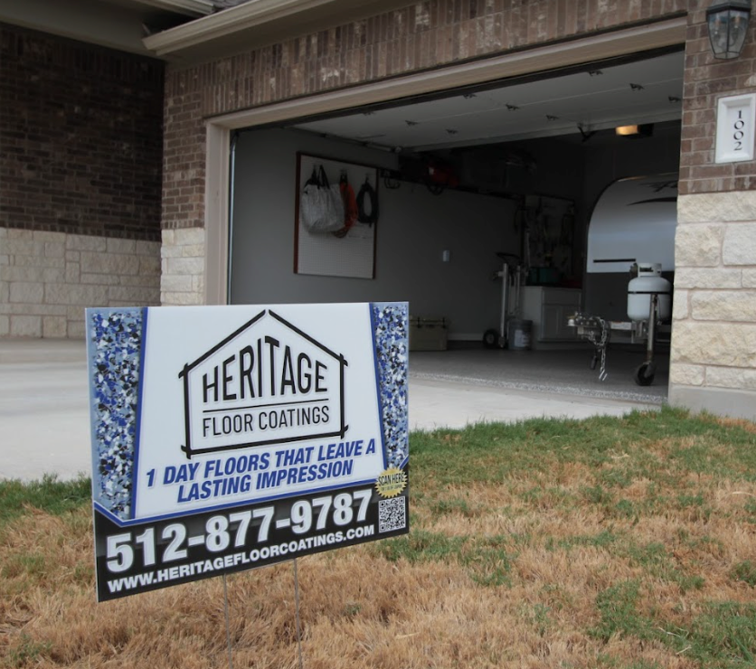 a heritage floor coatings sign in front of a garage