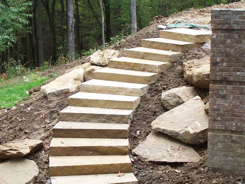 A set of stone stairs going up a hill