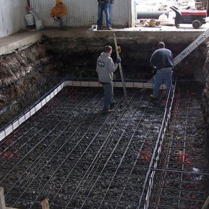 A group of men are working on a concrete floor.