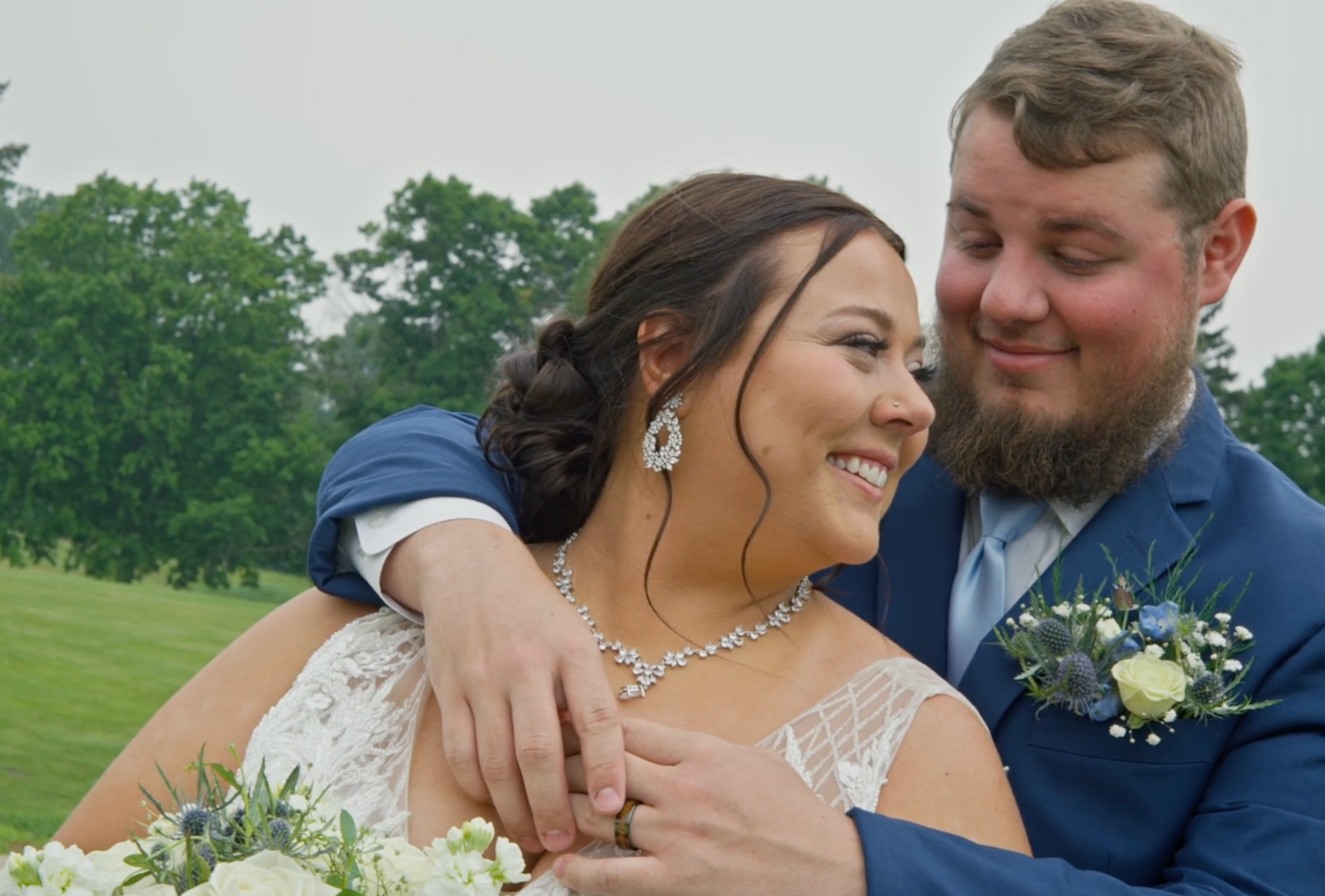 The groom has his arms around his bride on their wedding day in 2025.