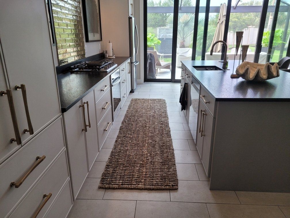A kitchen with a large island and a rug on the floor
