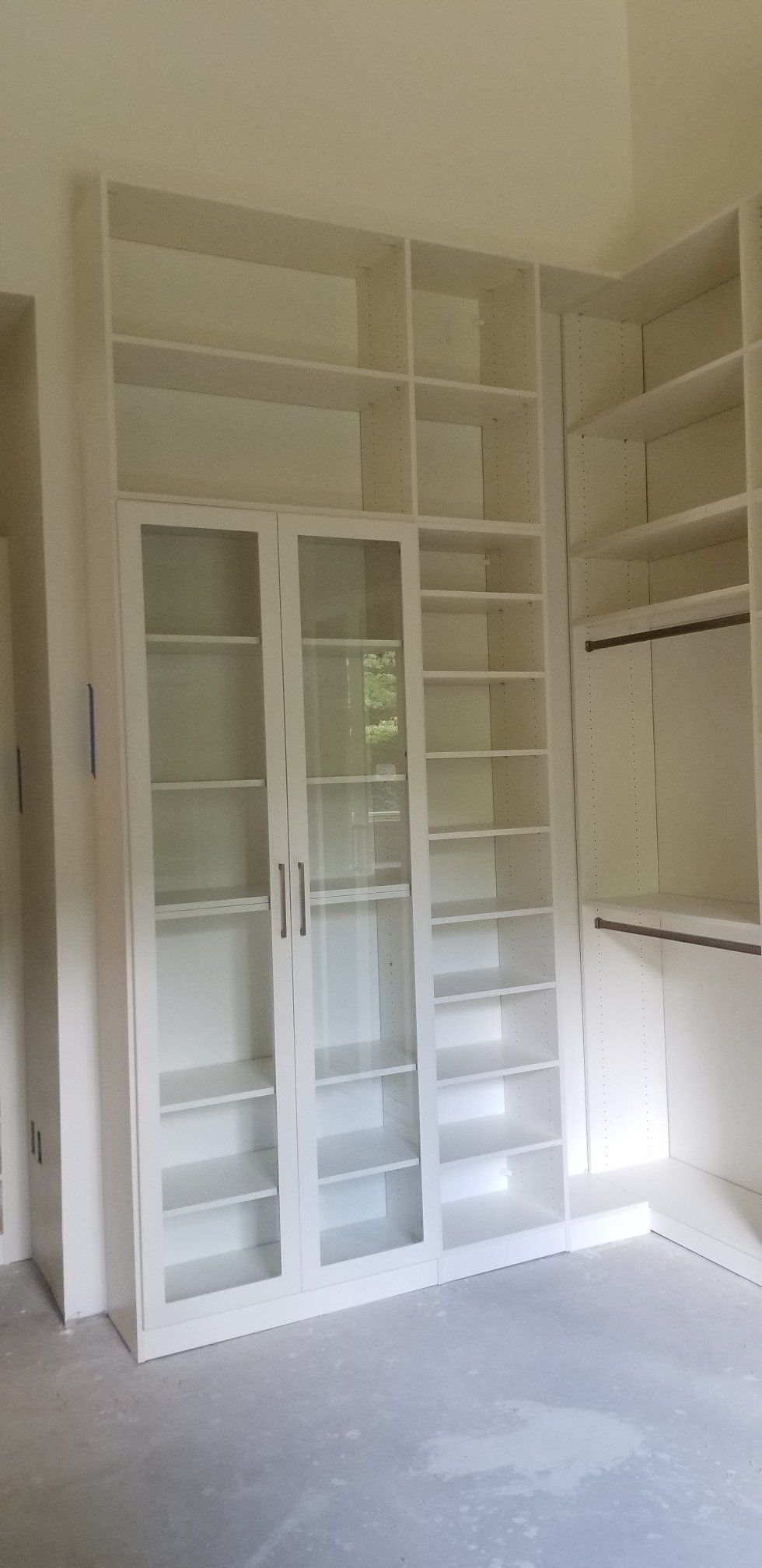 A room with a lot of shelves and glass doors.
