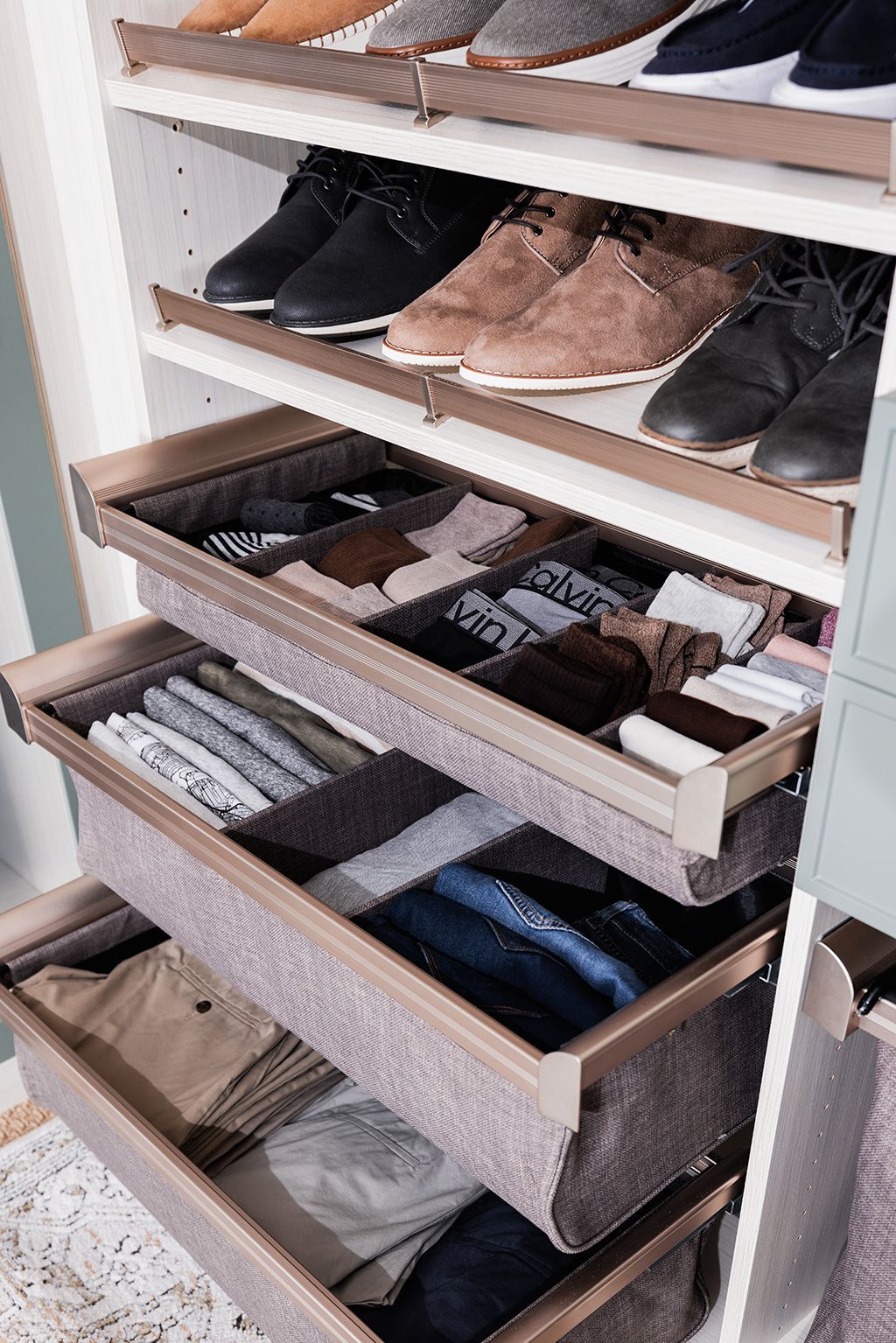 A closet with drawers filled with clothes and shoes.