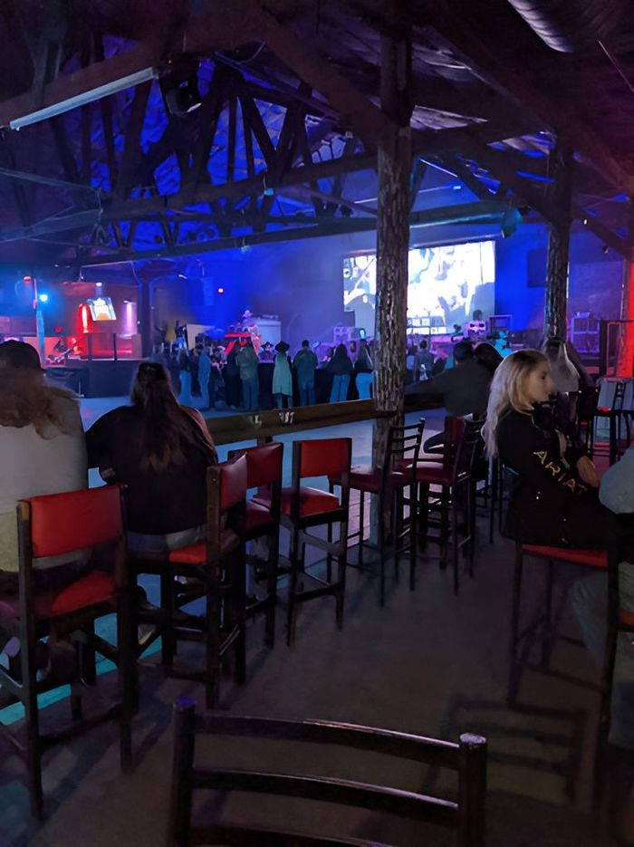 A group of people is having fun in front of a stage.