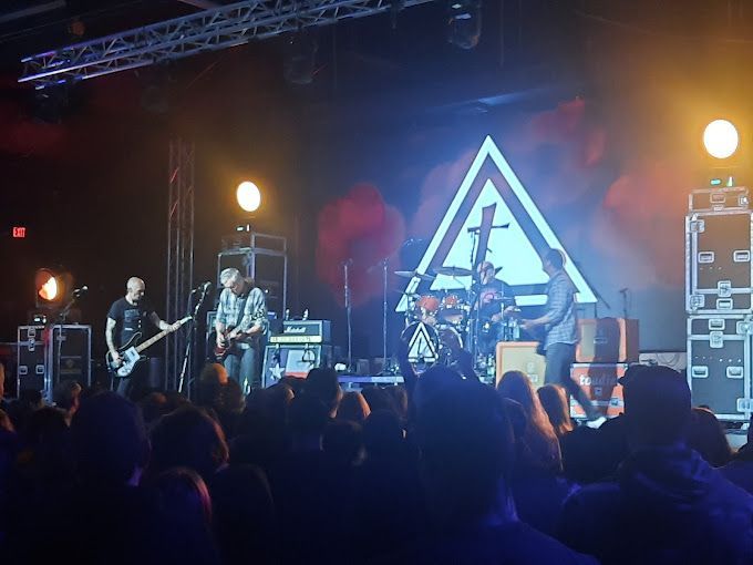 A band is performing on stage in front of a crowd.