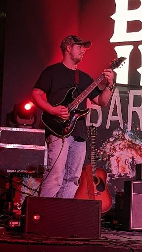 A man is playing a guitar on stage.