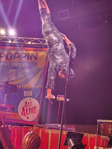A man is doing a handstand in front of a crowd.