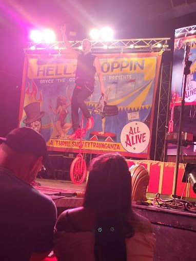 A man is riding a unicycle in front of an audience.